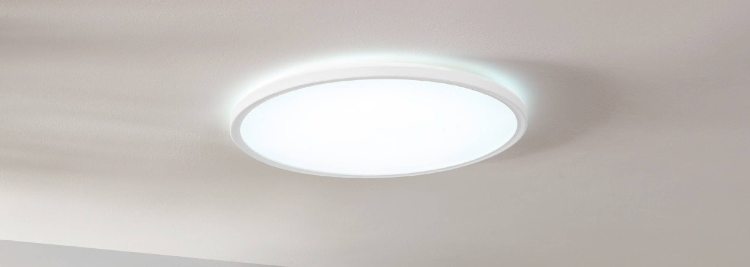 Weiße runde LED-Deckenleuchte an einer hellen Decke montiert.