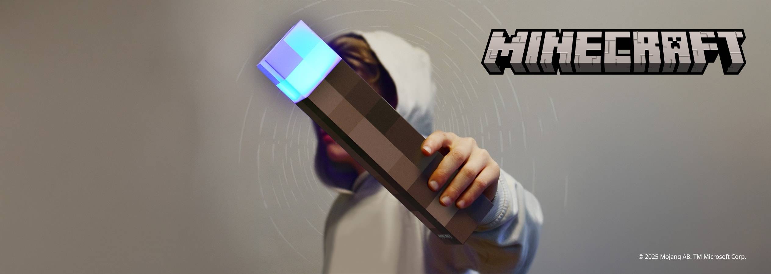 Un enfant tient une lampe torche Minecraft lumineuse.