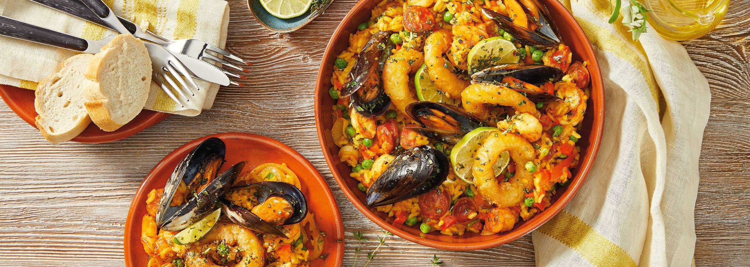 Una deliziosa paella di mare, servita con pane.