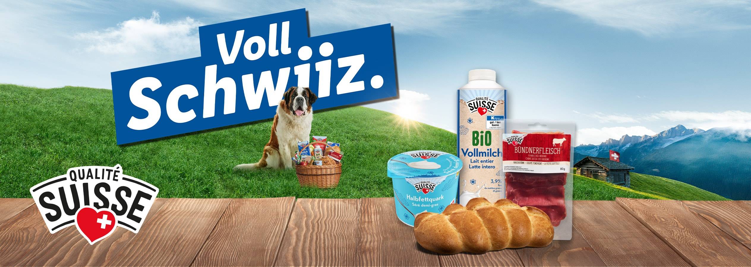 Schweizer Lebensmittel wie Milch, Bündnerfleisch und Quark auf einem Holztisch, mit einem Bernhardiner und Alpenlandschaft.