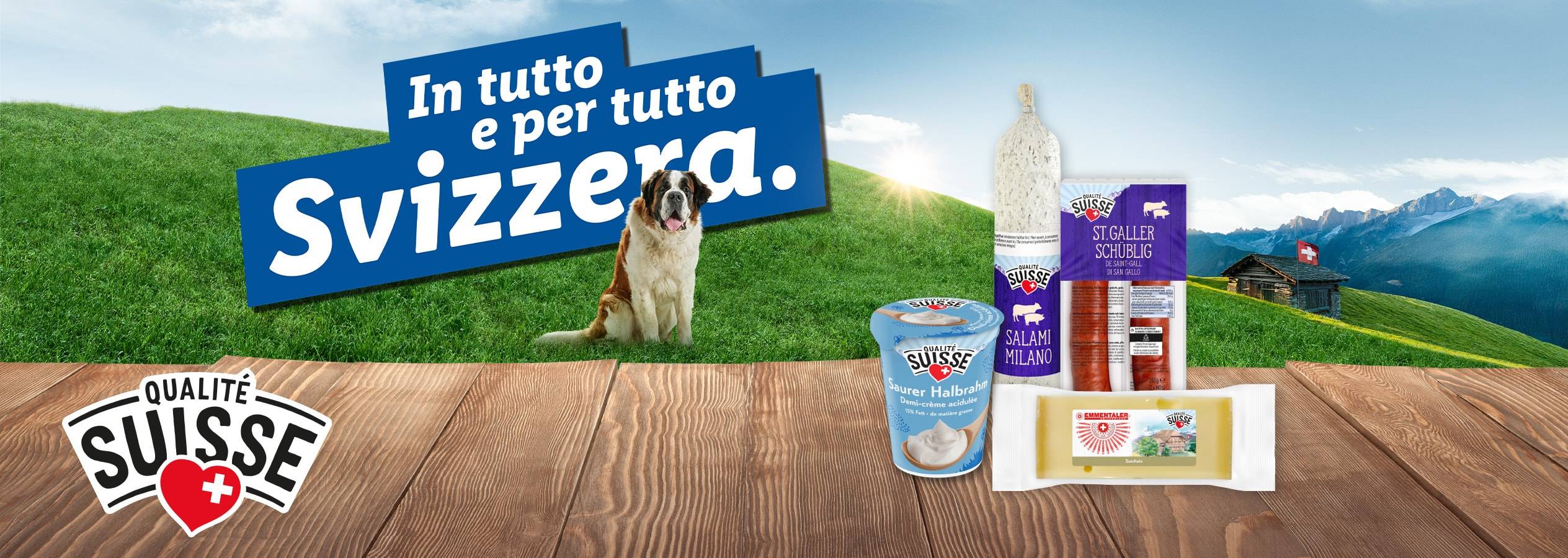 Prodotti alimentari svizzeri come salumi, latticini e formaggi, con un San Bernardo e un paesaggio alpino.