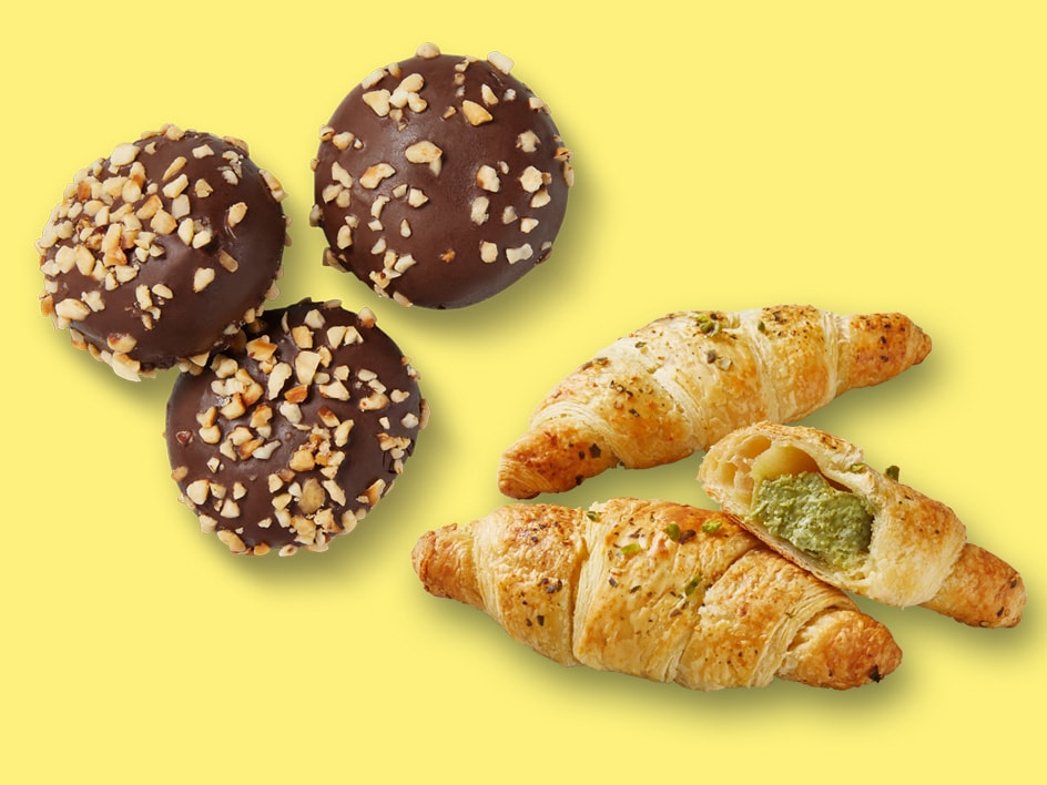 Drei schokoladenüberzogene Kugeln mit Nüssen und drei Croissants, eines davon mit Pistazienfüllung.