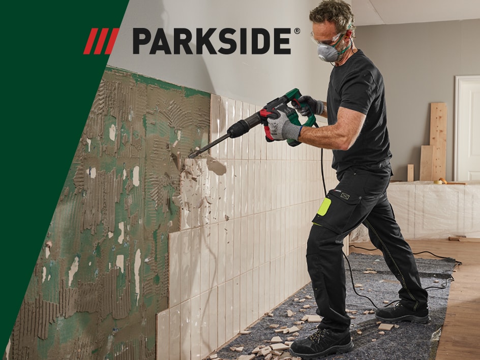 Un homme utilise un perforateur Parkside pour démolir des carreaux de mur.