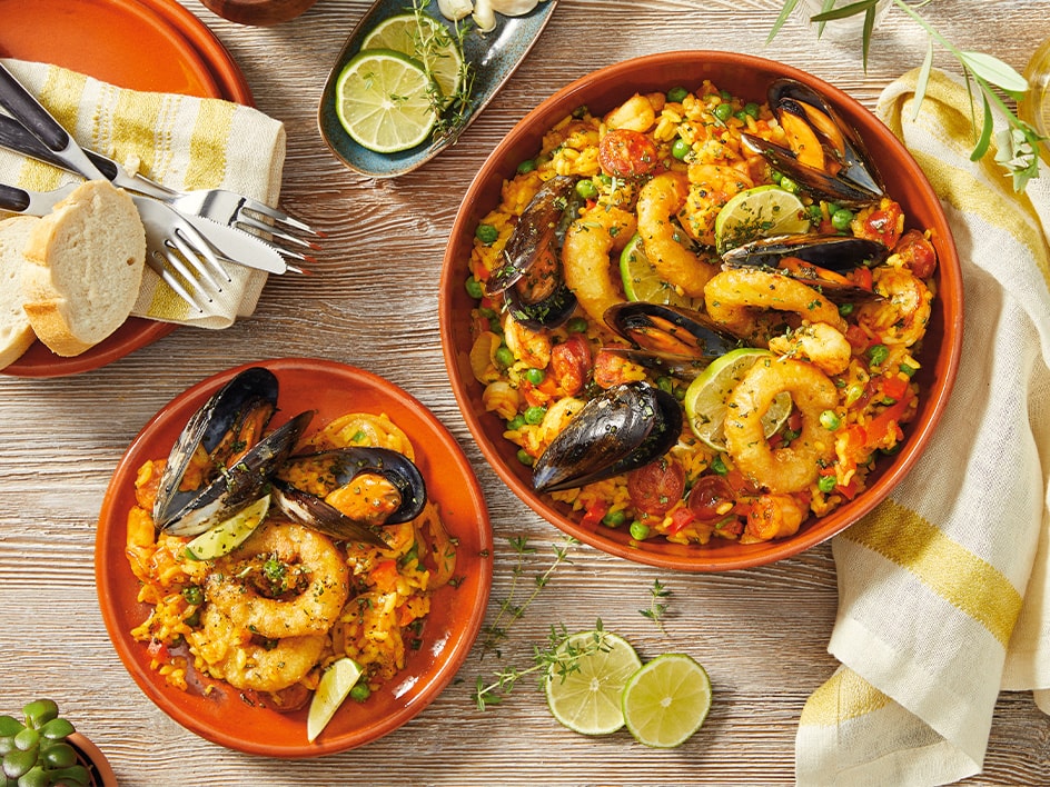 Una deliziosa paella di mare, servita in due ciotole di terracotta.