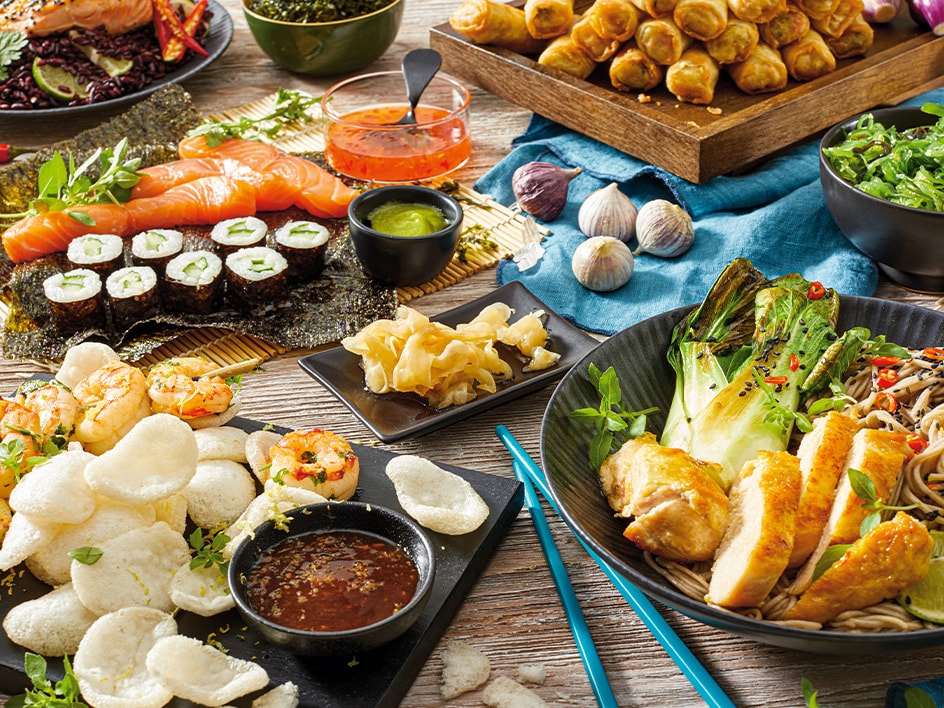 Un festin asiatique varié : sushis, rouleaux de printemps, poulet, nouilles et plus encore.