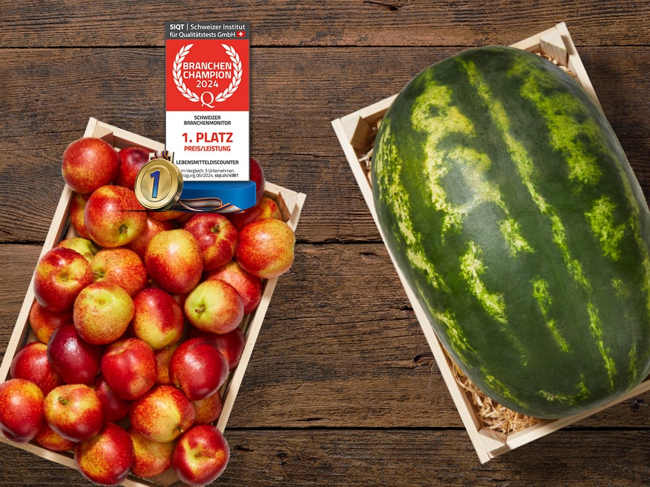 Wassermelonen und Nektarinen in Holzkisten, mit Preis-Auszeichnung.