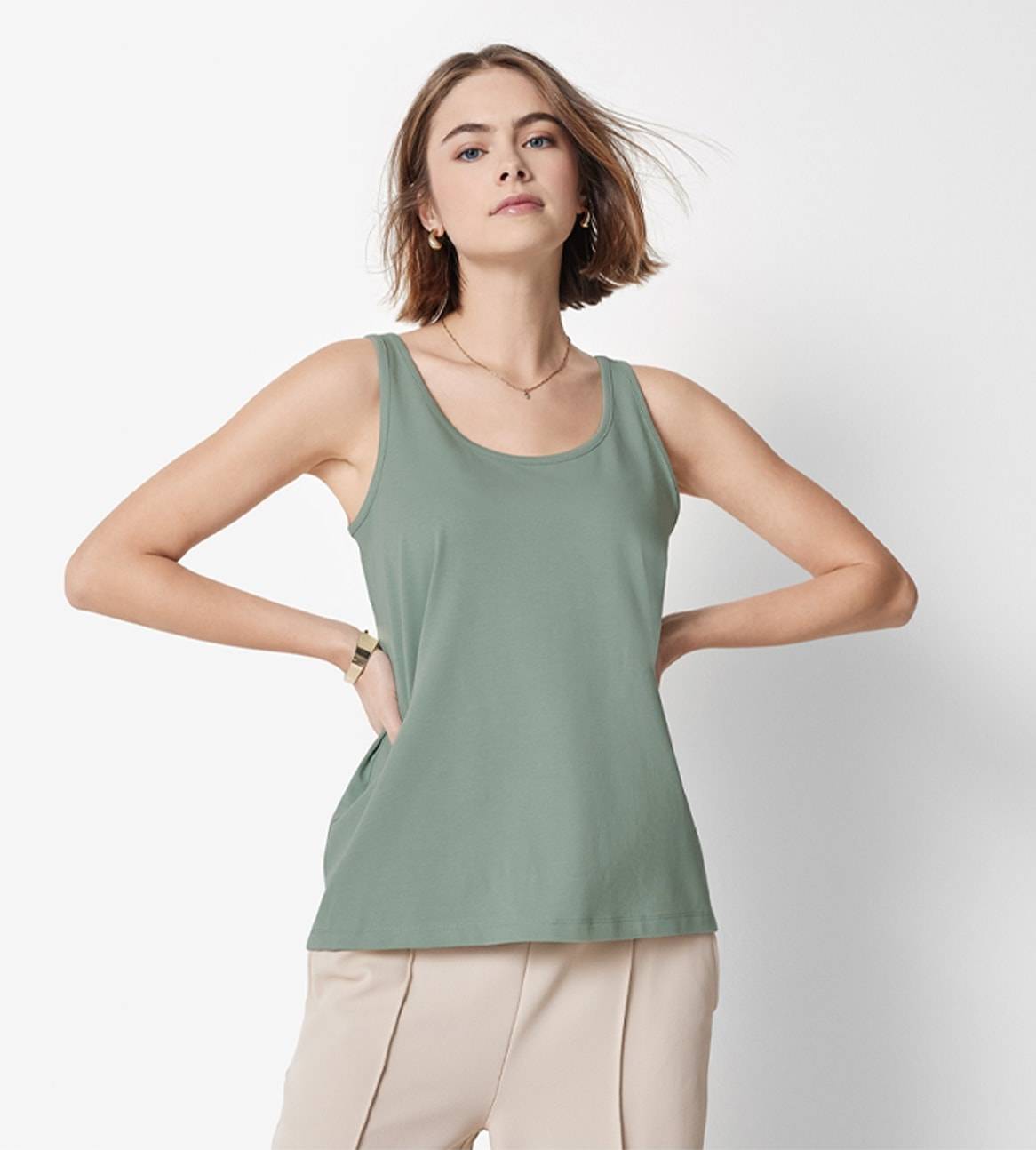 Eine Frau trägt ein elegantes, hellgrünes Tanktop.