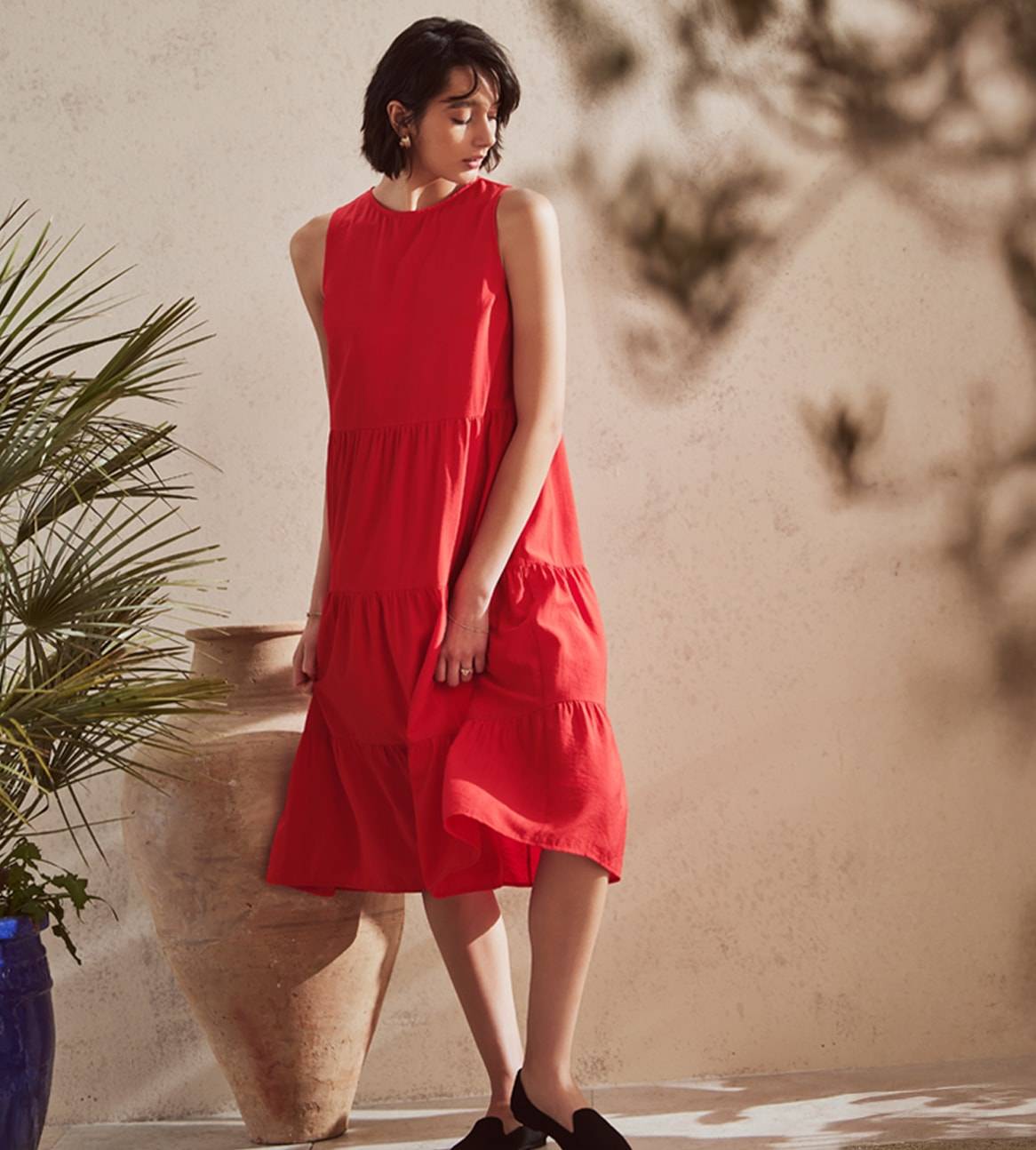 Ein Model trägt ein rotes, mehrlagiges Sommerkleid.