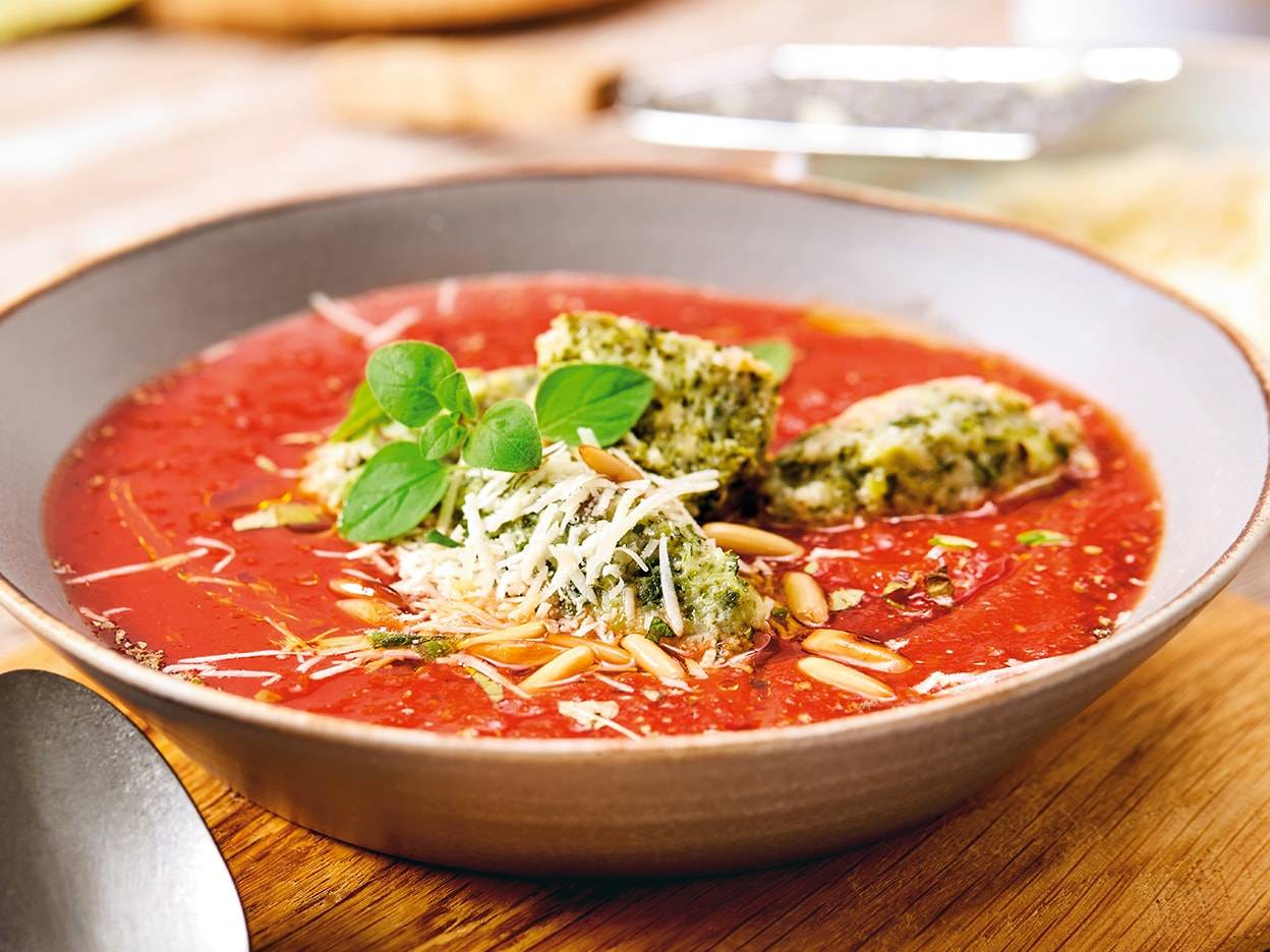 Tomatensuppe mit Pesto-Croutons und Parmesan.