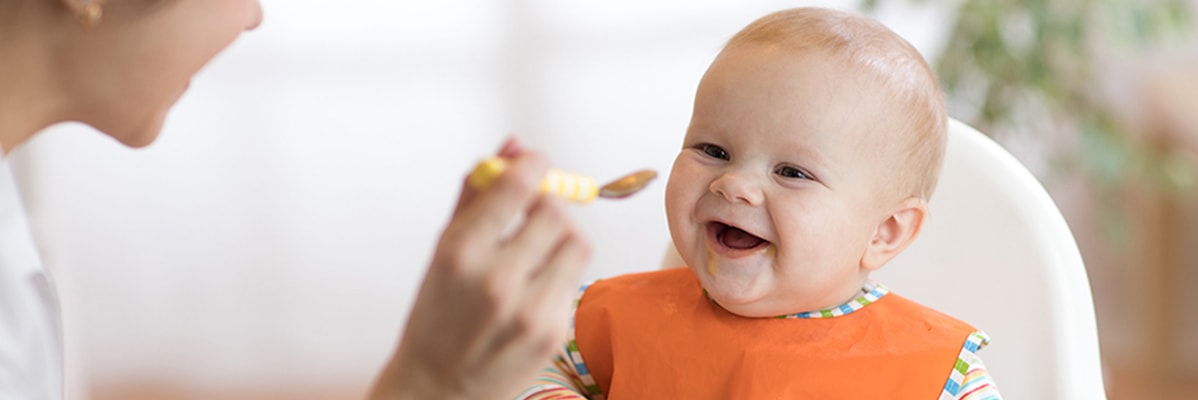 Bébé mange de la purée à la cuillère.
