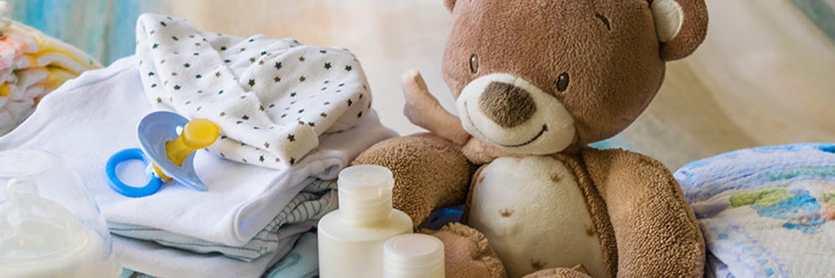 Abiti per neonati, ciuccio, orsacchiotto e prodotti per la cura del bambino.