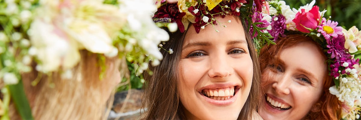 Donne con corone di fiori colorati.