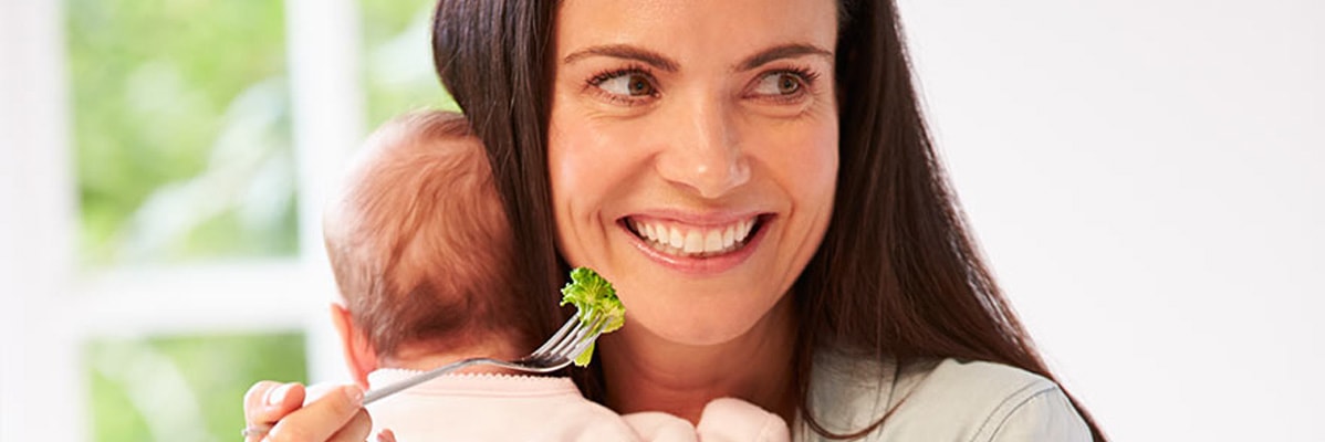 Mère nourrissant bébé avec du brocoli.
