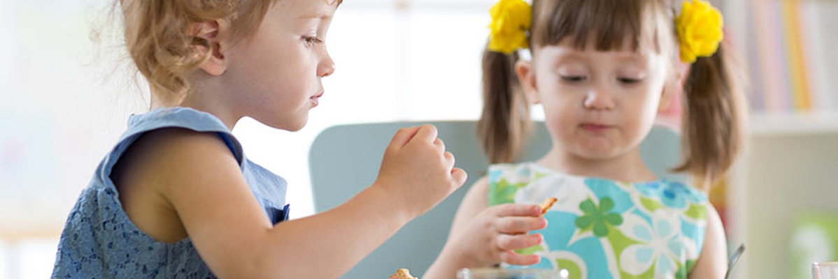 Deux petites filles mangent des crackers.