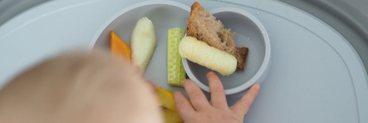 Baby isst Obst, Brot und Gemüse.