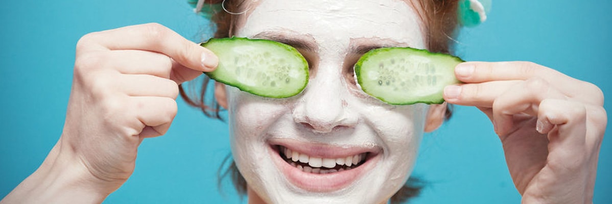 Gesichtsmaske und Gurkenscheiben für die Hautpflege.