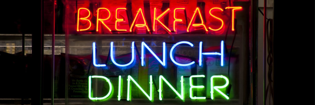 Frühstück, Mittagessen, Abendessen: Leuchtreklamen in Rot, Blau und Grün.