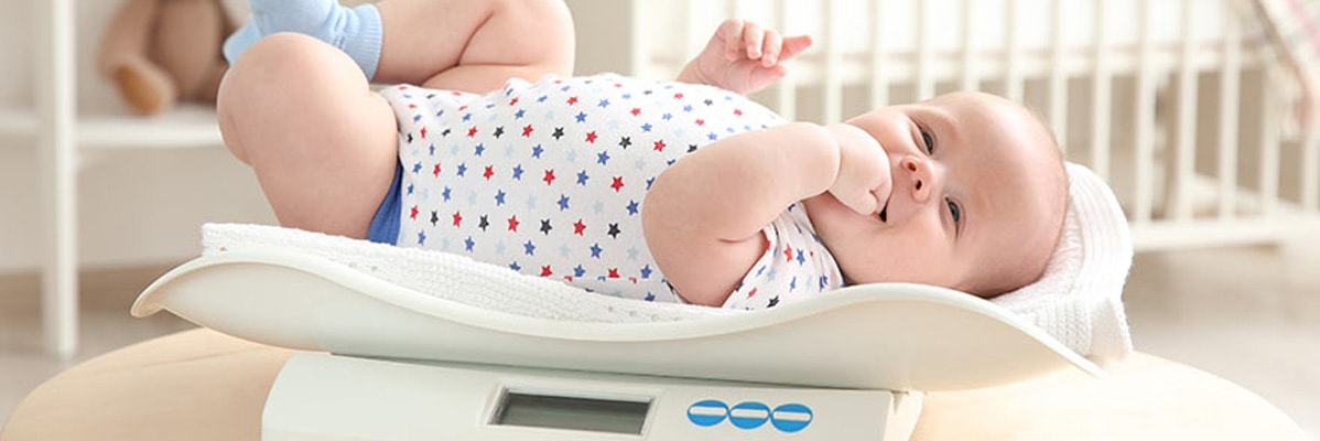 Neonato su un bilancia per neonati.