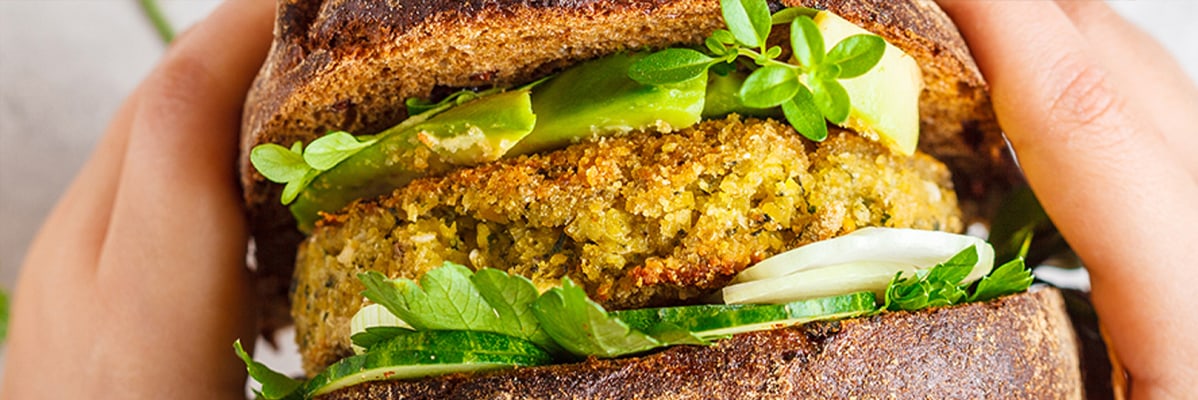 Burger végétarien avec avocat et pain complet.