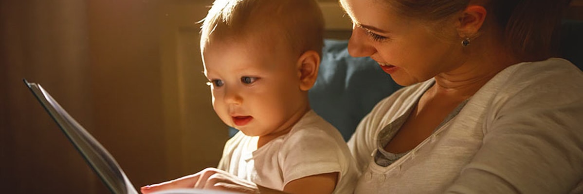 Une mère lit un livre à son bébé.