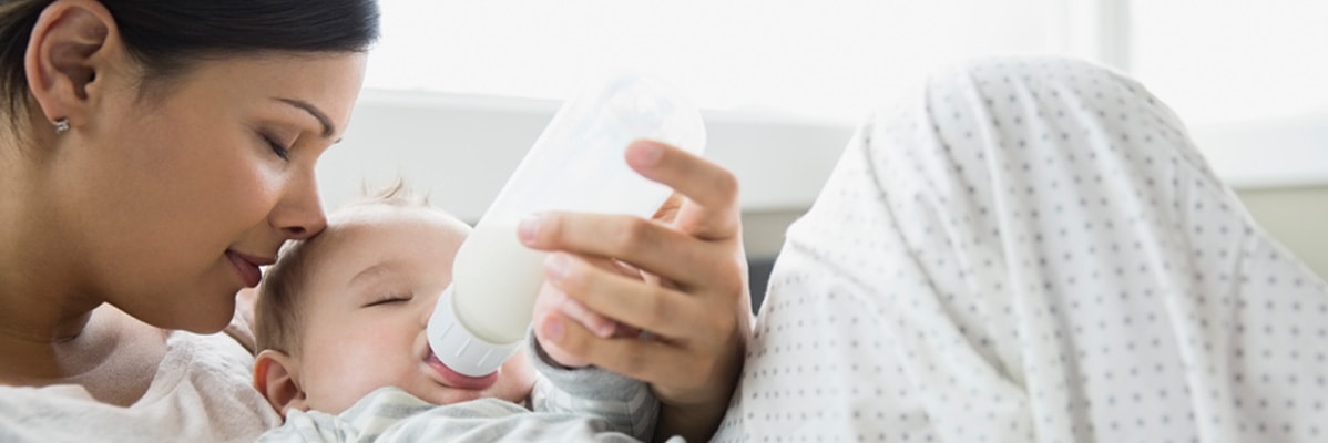 Mutter füttert Baby mit der Flasche.