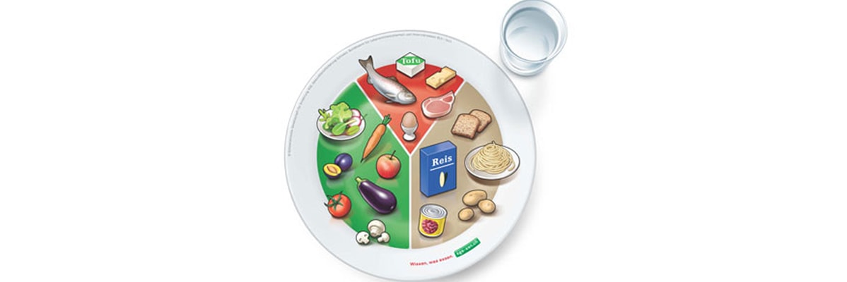 Assiette avec du poisson, du fromage, des pâtes et des légumes.
