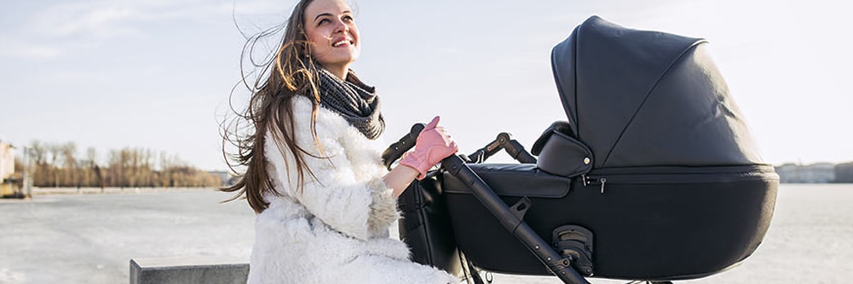 Femme avec une poussette en plein air.