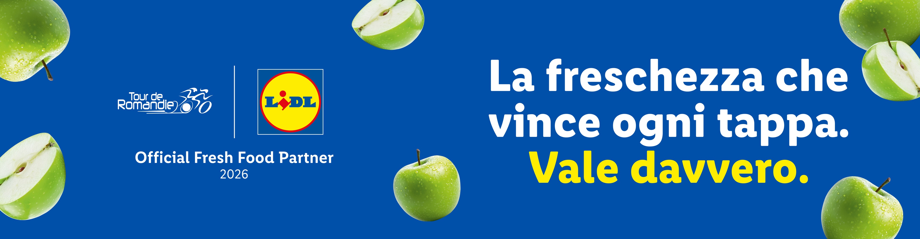 Mele verdi fresche su sfondo blu, con testo che celebra la freschezza e la partnership con un evento ciclistico.