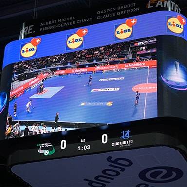 Un tabellone segnapunti a LED mostra una partita di pallamano con sponsorizzazioni Lidl.