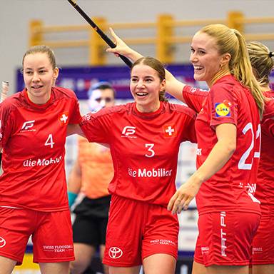 Giocatrici di floorball in maglie rosse con il logo della Federazione Svizzera di Floorball.