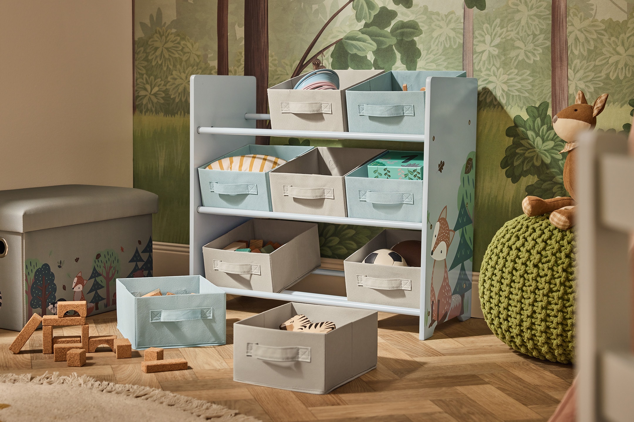 Kinderregal mit Stoffkörben und Spielzeugkiste im Waldthema.