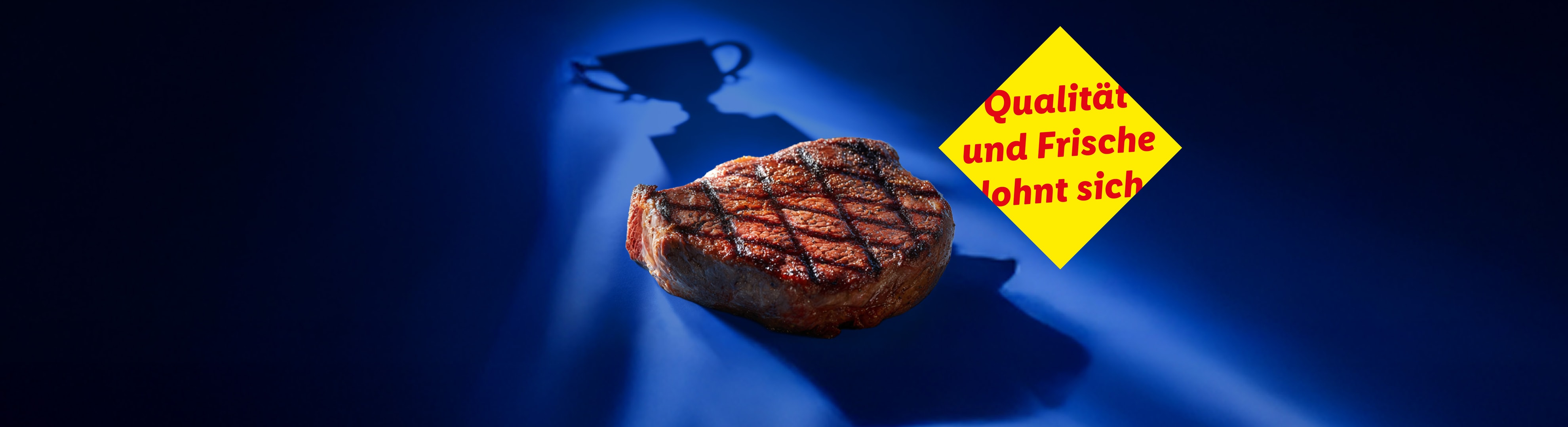 Gegrilltes Steak mit dem Schatten eines Pokals und einem gelben Schild mit der Aufschrift „Qualität und Frische lohnt sich“.