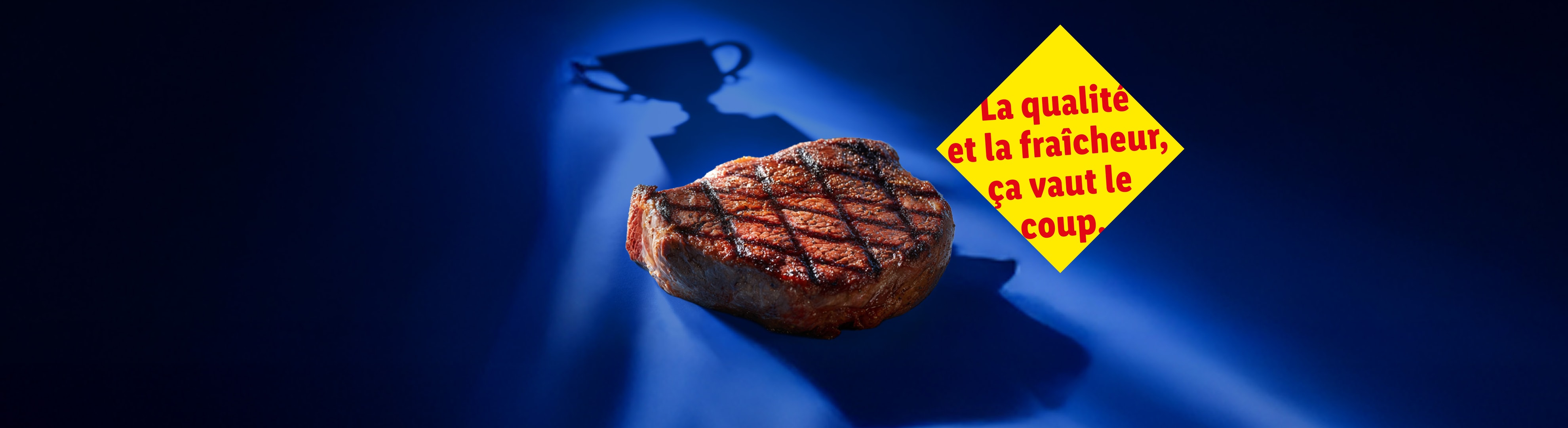 Un steak grillé avec l'ombre d'un trophée et un message jaune sur fond bleu.