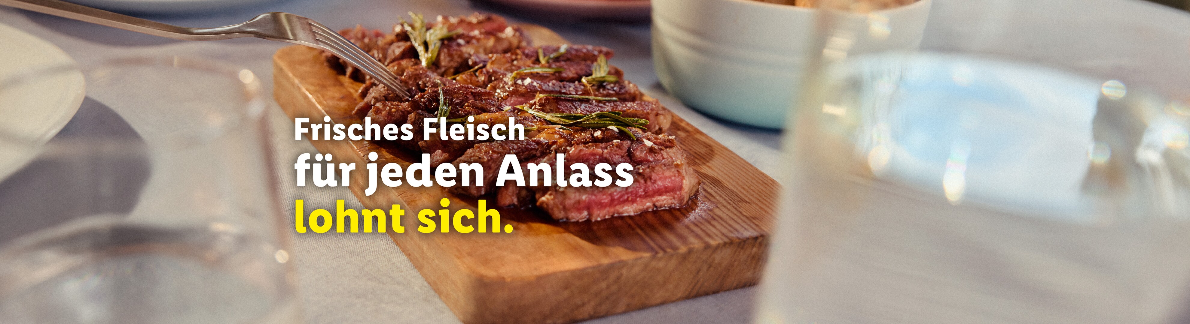 Geschnittenes Rindersteak auf einem Holzschneidebrett mit Rosmarin.