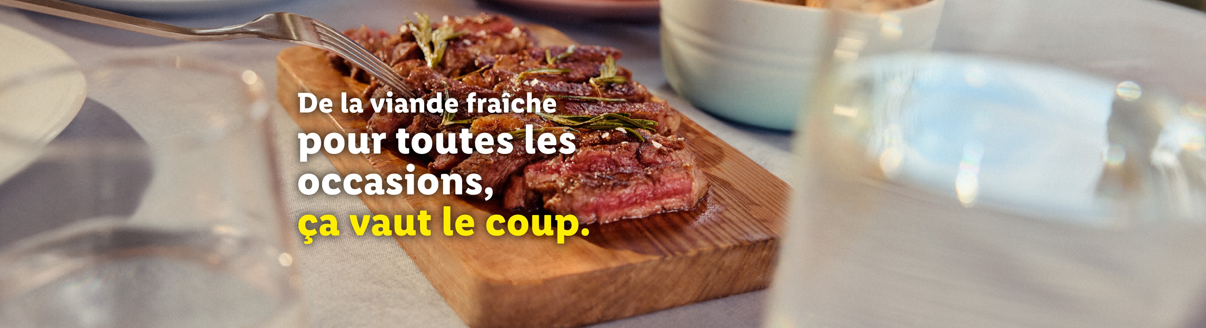 Steak de bœuf tranché sur une planche à découper en bois avec du romarin et du sel.