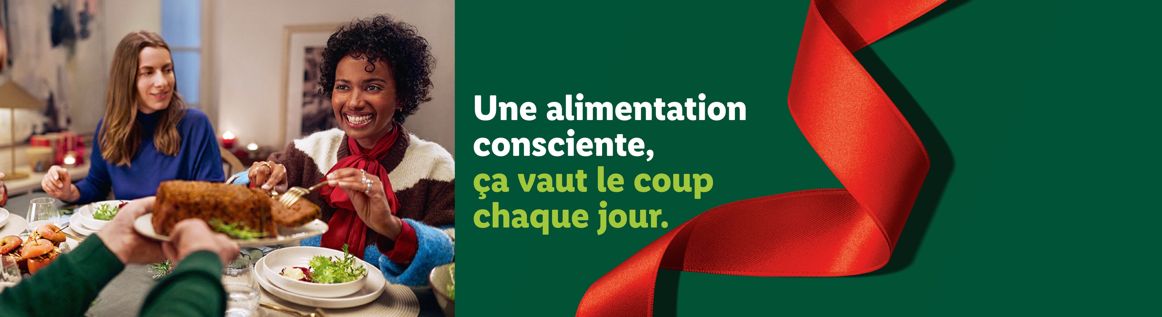 Deux femmes souriantes à table, avec un ruban rouge sur fond vert.