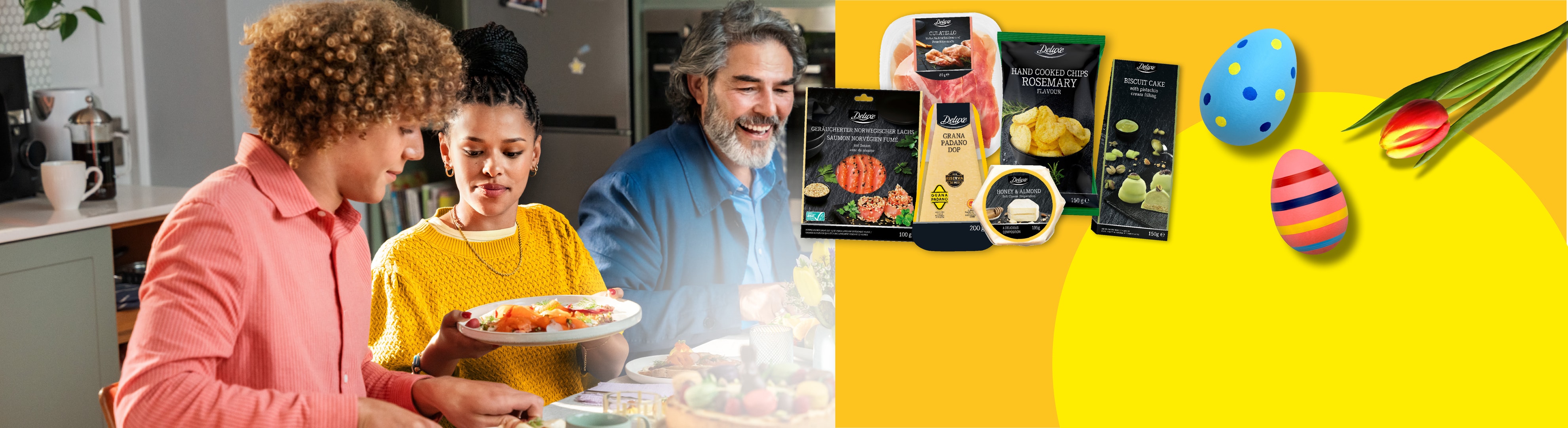 Eine Familie teilt ein Ostermahl mit Wurstwaren, Käse, Chips, Kuchen und dekorierten Eiern.