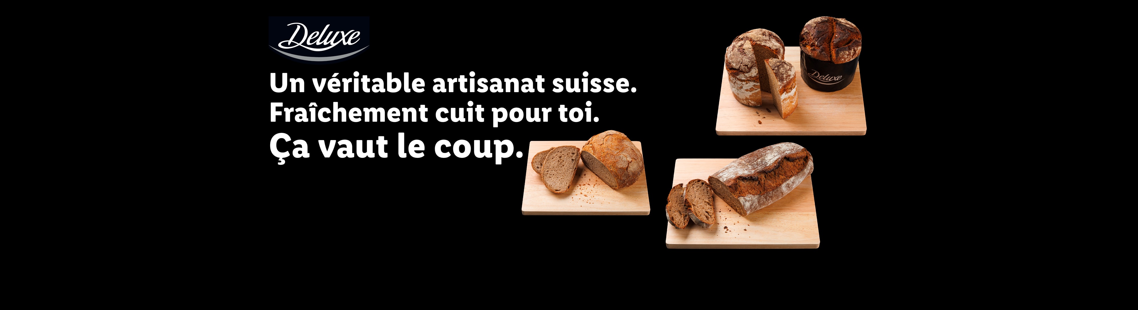 Pains artisanaux suisses fraîchement cuits sur des planches à découper en bois, avec le texte : « Un véritable artisanat suisse. Fraîchement cuit pour toi. Ça vaut le coup. »