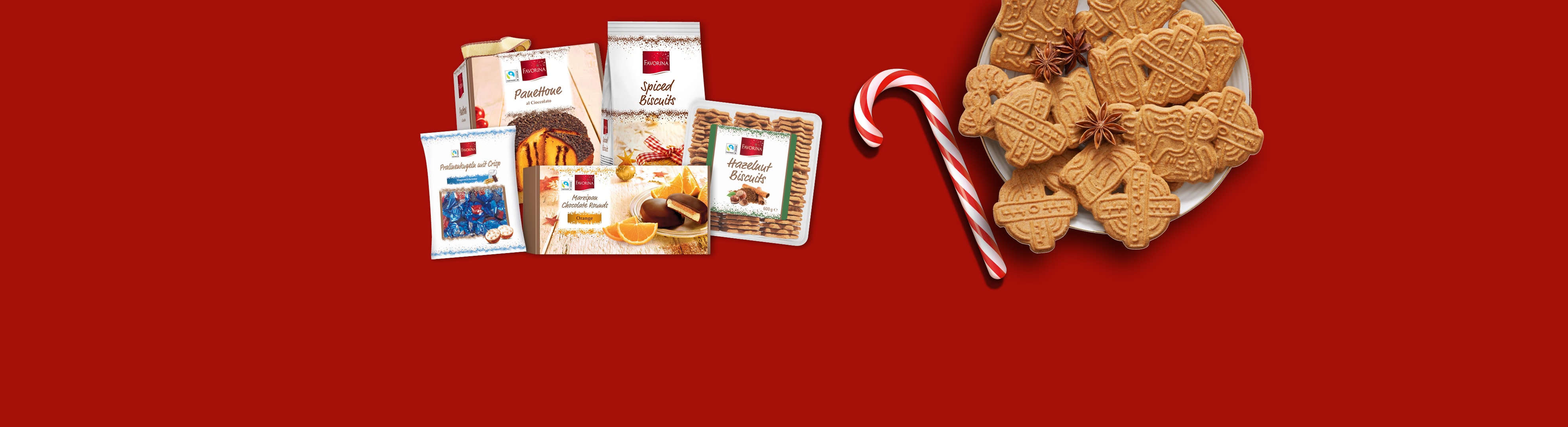 Biscotti di Natale Favorina, panettone e praline su sfondo rosso.