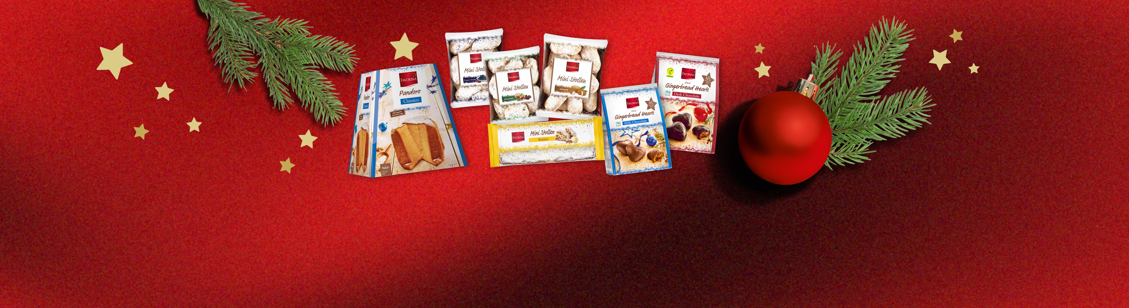 Favorina Weihnachtsprodukte: Pandoro, Mini Stollen und Lebkuchenherzen auf festlichem Rot.