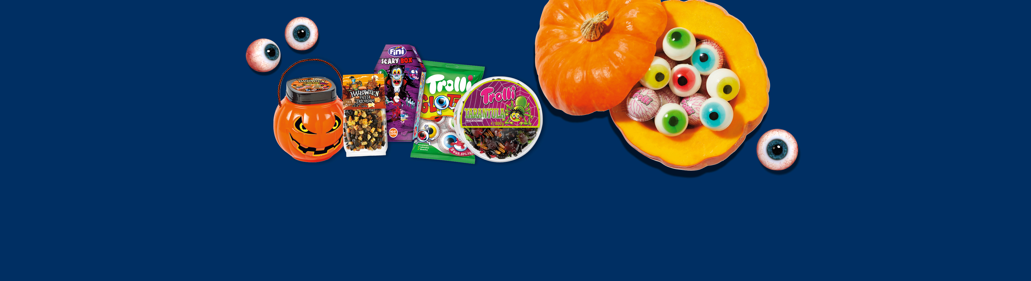 Bonbons d'Halloween et pâtes en forme de citrouille, avec des bonbons en forme d'yeux et des tarentules.