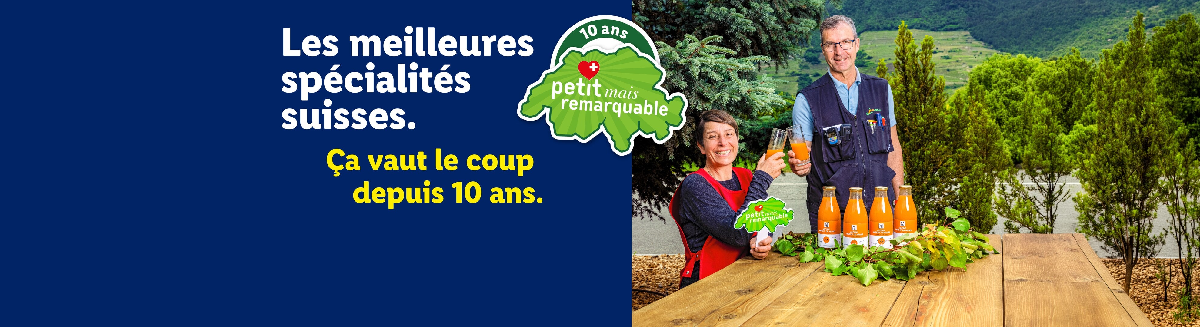 Deux personnes trinquent avec du jus de carotte pour célébrer 10 ans de spécialités suisses.