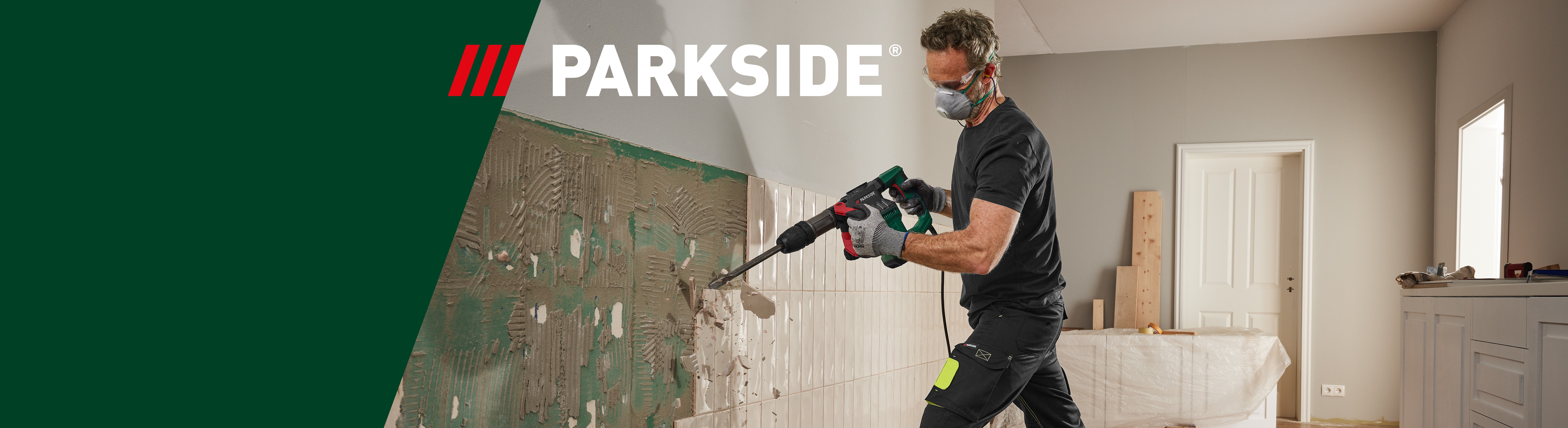 Un homme utilise un perforateur Parkside pour enlever des carreaux de mur.
