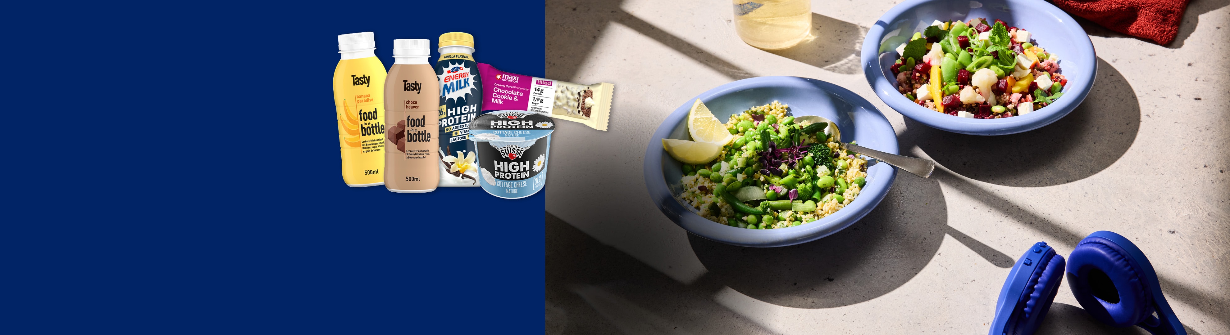 Lidl-Produkte: Proteinriegel, Cottage Cheese, Proteinmilch und Salate in blauen Schalen.