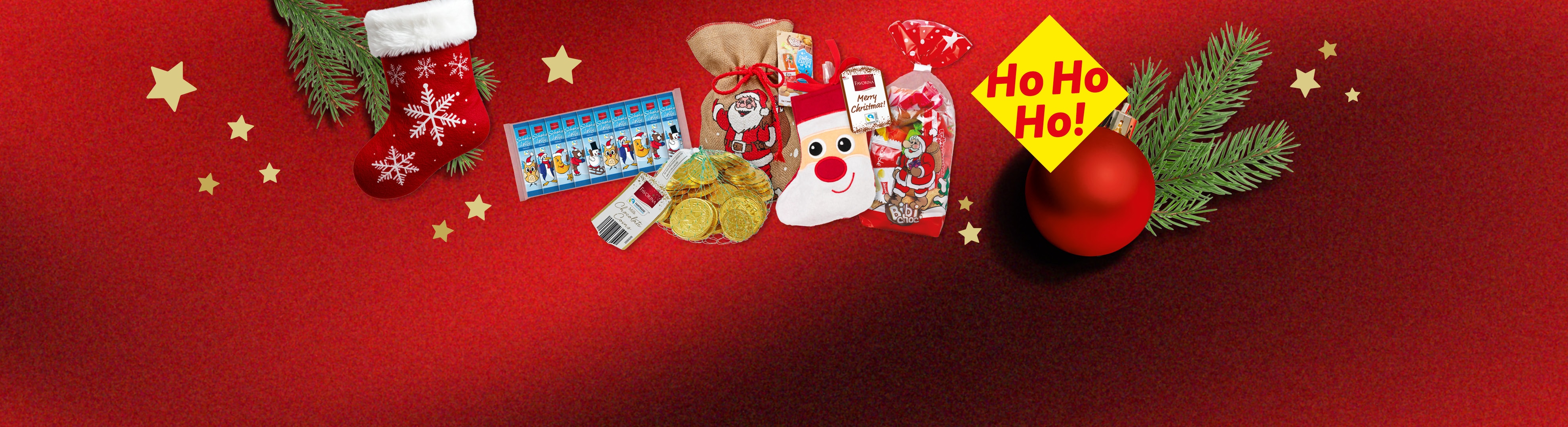 Weihnachtliche Süßigkeiten und Dekorationen auf rotem Hintergrund mit Sternen.