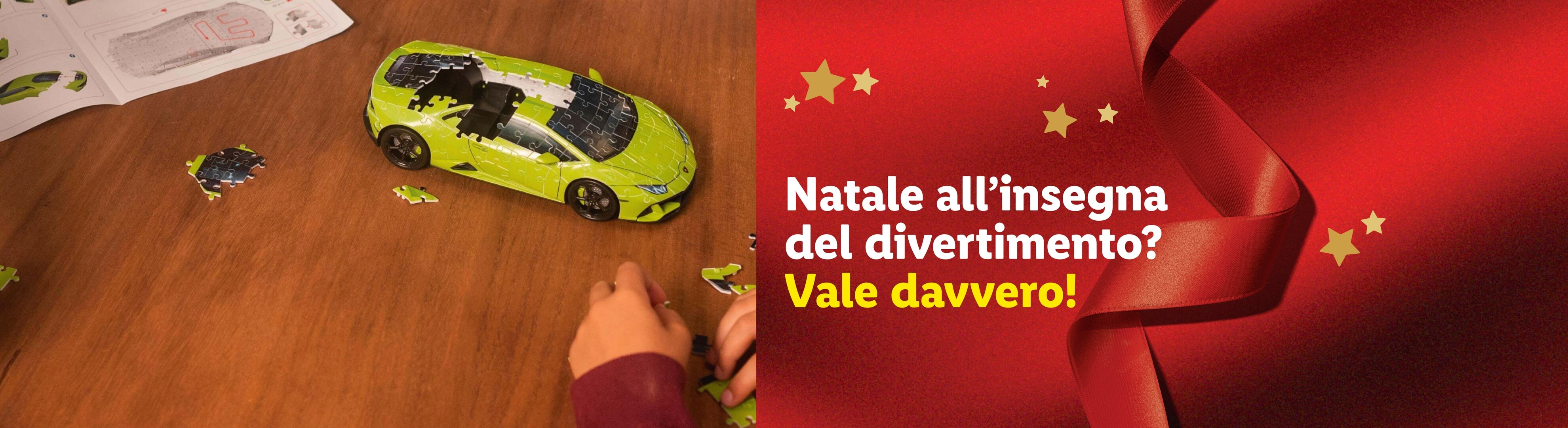 Un puzzle 3D di un'auto sportiva verde su un tavolo di legno, con testo a tema natalizio.