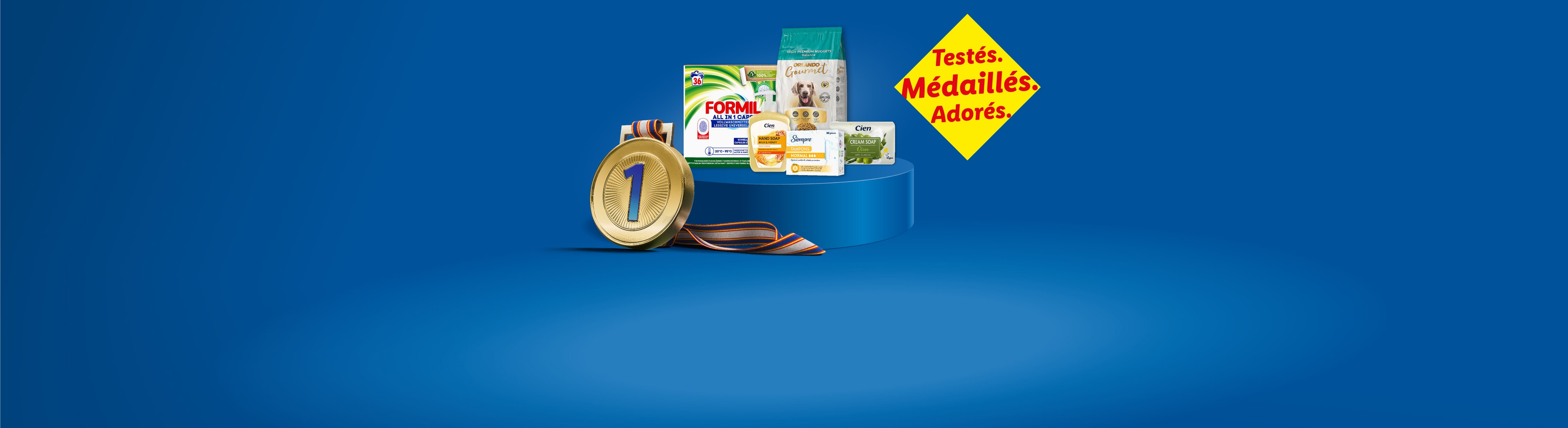 Une médaille d'or et des produits ménagers et de soins personnels sur fond bleu, avec le texte 'Testés. Médaillés. Adorés.'