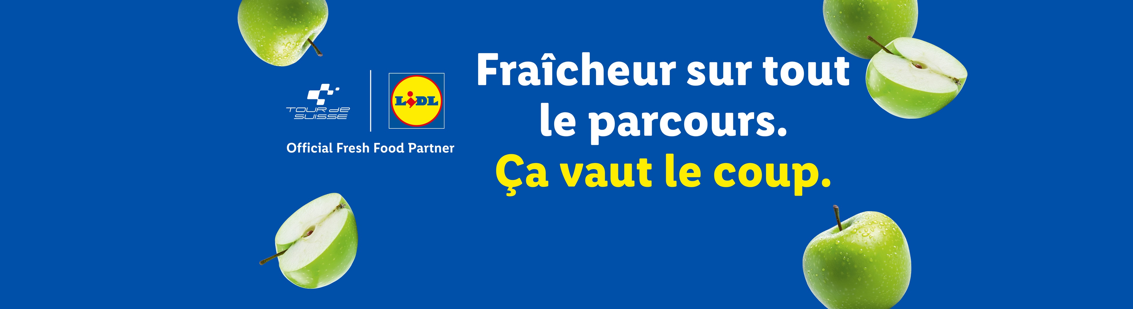 Pommes vertes fraîches sur fond bleu avec le texte 'Fraîcheur sur tout le parcours. Ça vaut le coup.'