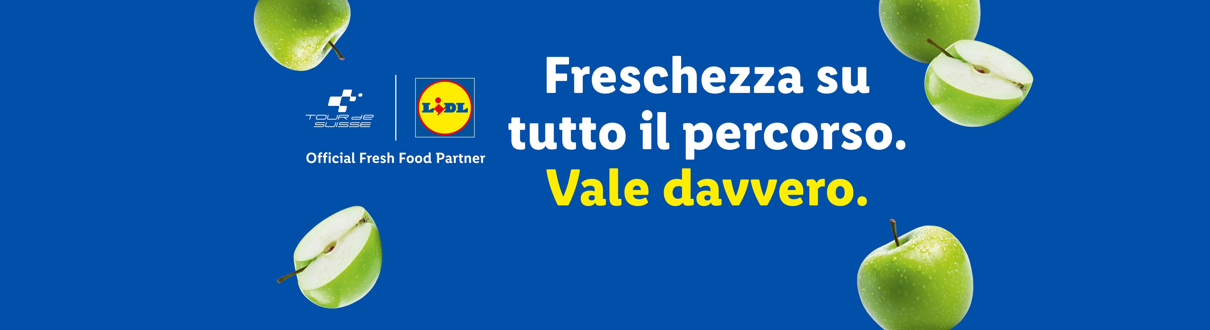 Mele verdi su sfondo blu con testo: Freschezza su tutto il percorso. Vale davvero.