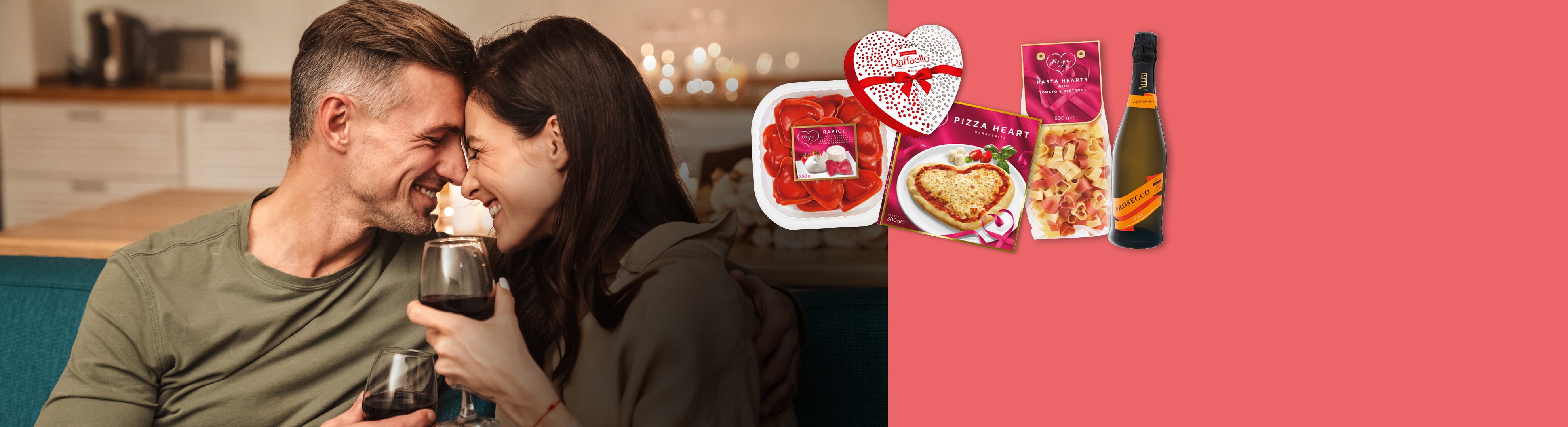 Couple heureux avec du vin et des produits en forme de cœur : raviolis, pizza, pâtes, chocolats et prosecco.